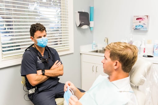 Dentist explaining out of pocket costs to a patient in a dental chair