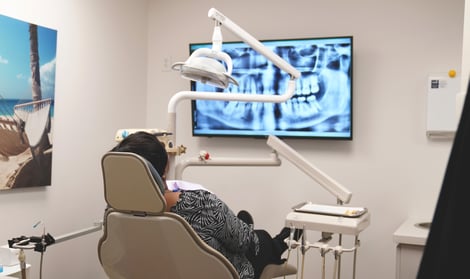 Dental patient in the chair after they've already paid for treatment, helping reduce write-offs for the dentist.